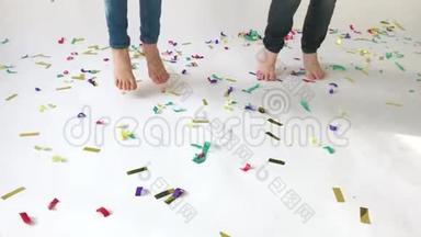 孩子们`脚跳在铺有彩色纸屑的地板上