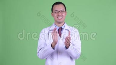 戴眼镜的亚洲快乐男医生拍手
