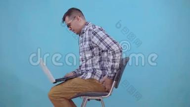 坐在笔记本电脑上工作的人因痔疮而感到疼痛和不适
