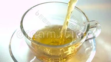 在白色背景特写镜头上，将茶壶中的红茶香气注入一个匹配的透明玻璃茶杯。