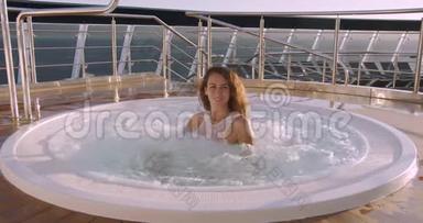 女士在豪华度假酒店的室外热水浴缸按摩浴缸中放松。