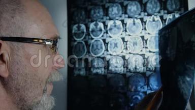 一位戴眼镜的老年科学家<strong>回顾</strong>脑部核磁共振