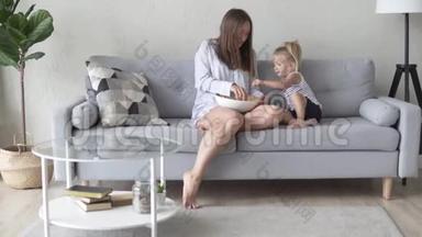 妈妈和女儿坐在他们的睡衣沙发上