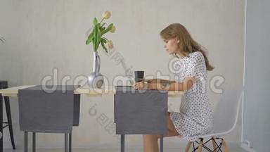 年轻女孩<strong>在家</strong>里的客厅里的一张桌子<strong>上</strong>在<strong>线上</strong>输入笔记本电脑