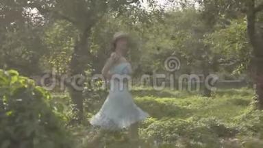 可爱的年轻女子戴着草帽，穿着白色的长裙，穿过绿色的夏日花园。 免费<strong>农村生活</strong>