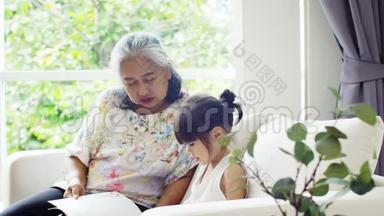 老奶奶和小孙女在沙发上看书