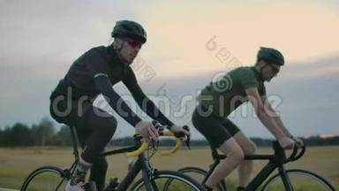 傍晚日落后，两个骑自行车<strong>的人</strong>骑在路上.. 清晨训练骑自行车<strong>的人戴头盔</strong>。