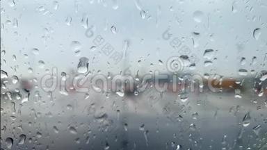 在暴雨时，通过机场候机楼覆盖水滴的飞机舷窗特写4k视频