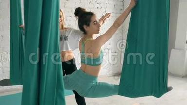 瑜伽练习有助于女学生伸展腿部，在空中Silk上做分裂动作