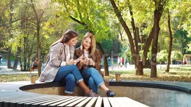 快乐的女孩在公共公园使用智能手机浏览社交媒体