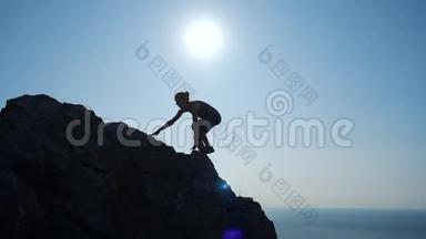 年轻女子缓慢地向山顶走去. 一位<strong>女士</strong>在美丽的克里米亚山区徒步旅行的<strong>剪影</strong>。