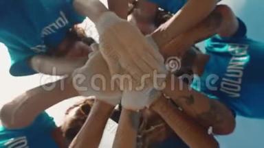 团体志愿者把他们的双手<strong>放在一起</strong>，作为团结和团队合作的象征