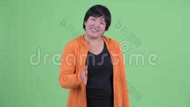 快乐年轻、体重超重的亚洲女人为健身房准备握手