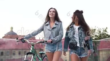 在阳光明媚的夏<strong>日</strong>，两位年轻迷人的城市妇女在街上骑自行车和<strong>滑板</strong>散步。