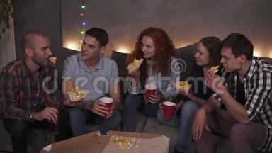 <strong>年轻人</strong>，快乐的男人和女人正在吃奶酪披萨，在公寓的室内<strong>聚会</strong>上聊天放松
