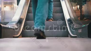 人们的腿在商场的自动扶梯电梯上移动。 购物中心`扶梯上的购物者脚