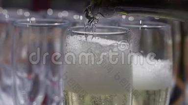 巨大的香槟。 香槟正倒入玻璃杯中。 有人在往玻璃杯里倒起泡的酒. 香槟酒