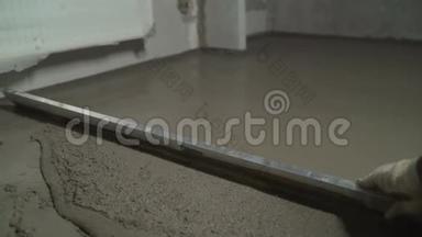 地板平整。 用一种自平化合物填充地板。 工人用灰泥铺地板
