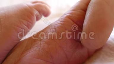 合上婴儿的脚，她爸爸用手指轻轻<strong>抚摸</strong>婴儿的脚