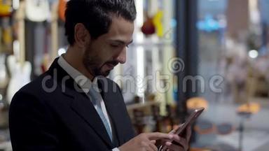 年轻英俊的企业站在一边使用智能手机