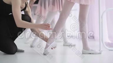 穿着白袜子和芭蕾<strong>舞鞋</strong>的小女孩无法辨认，她们的芭蕾舞老师纠正她们