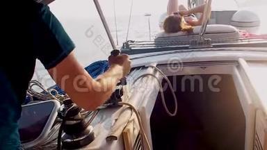乘游艇航行在帆下，男游艇司机在绞车上系绳