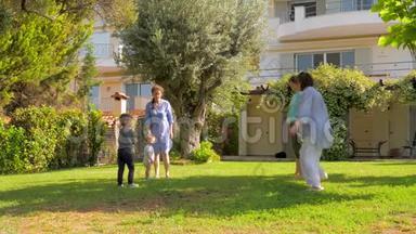 幸福的一家人在豪宅、别墅前院慢动作跳跃。 暑假概念。 暑假期间