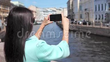 微笑旅游妇女在欧洲城市中欣赏水上运河和城市景观拍摄视频