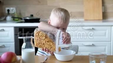 可爱的男孩4岁在家里的<strong>桌子</strong>上吃<strong>早餐</strong>玉米片和牛奶。
