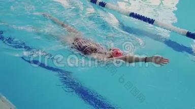 专业年轻女子游泳仰泳时的俯视图。 她为大众的竞争做准备