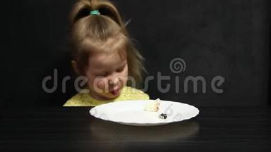 三岁的女孩吃奶酪蛋糕