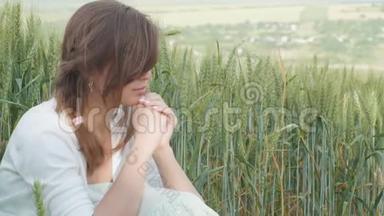 年轻的女孩祈祷着祈祷的<strong>话语</strong>，在田野里看着天空，一个女人在谷物小穗中享受着大自然，而不是
