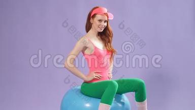 女士在家接受健身训练，<strong>双</strong>手分开，<strong>双</strong>手放在腰部和腿部，坐在健身球上