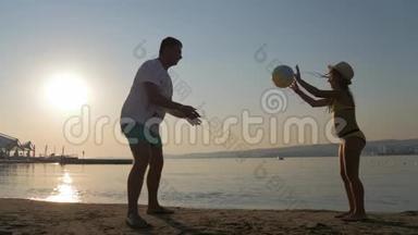 夏天<strong>一家人</strong>在海滩上打球。 父亲和<strong>女儿</strong>在户外踢足球。 友好家庭观念..
