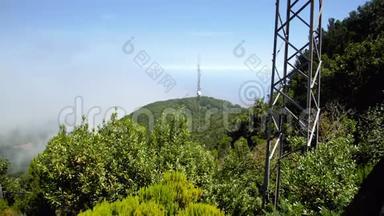 高山峰上高广播或电视塔的4K镜头，上面长满了森林。 通信技术