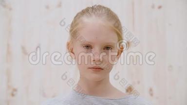 肖像悲伤的女孩少年看着镜头在灯光工作室。 闭上脸沮丧的女孩悲伤地看着镜头
