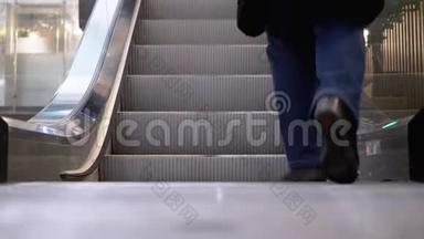 人们的腿在<strong>商场</strong>的自动扶梯电梯上移动。 购物<strong>中</strong>心`扶梯上的购物者脚