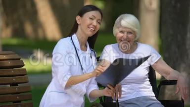 微笑女医生给坐轮椅的快乐老年妇女做脊柱x光检查