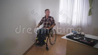 残疾人在轮椅上选择与心爱的儿子在房间里选择壁纸，在修理期间选择家庭关系