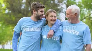 三个快乐的积极分子在<strong>志愿者</strong>T恤衫拥抱，生态项目的成就