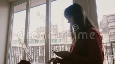成功自信的年轻女商人在巴黎酒店窗口用笔记本电脑和智能手机微笑，<strong>火车经过</strong>。