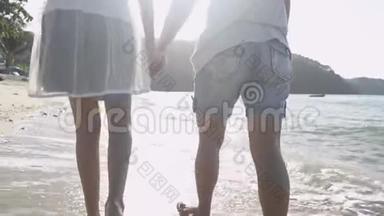 夏天，妈妈和女儿一起在阳光下快乐地在海滩上<strong>散步</strong>和<strong>牵手</strong>。