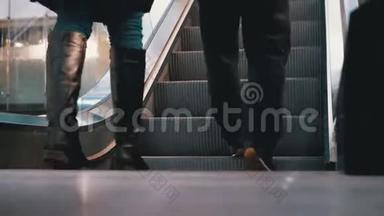 人们的腿在商场的<strong>自动</strong>扶梯<strong>电梯</strong>上移动。 购物中心`扶梯上的购物者脚
