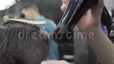 一个理发师用吹干机<strong>剪开</strong>的头发，同时给客户做发型