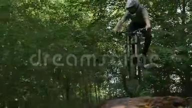 骑自行车的人戴着安全帽骑着山地车在森林的跳板上骑着
