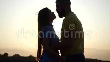 一对年轻迷人的夫妇在日落时牵手在<strong>乡村</strong>风景中的<strong>爱情</strong>故事。 留胡子的年轻人和