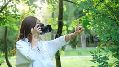 穿着白色衬衫的漂亮女孩摄影师正在拍照片，在拍照片之前，她的手指上显示了她的想法