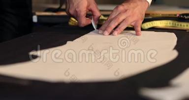 一个裁缝用粉笔在布料上画线条，并在剪裁周围做一些改动