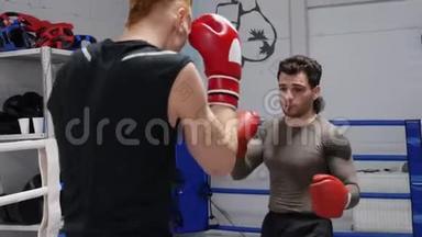 两名拳击手在拳击俱乐部一起训练拳击。 拳击手训练拳击手套和拳击手