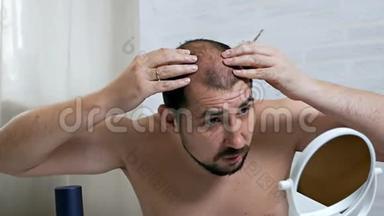担心<strong>脱</strong>发。 镜子前一个秃顶的人照顾他的头发，用一种方法来生长头发，以<strong>防</strong>万一